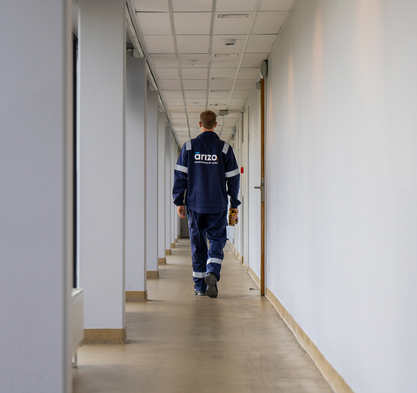 Un employé d'Arizo marche dans un couloir.